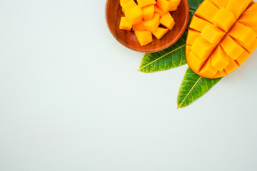 Fresh and beautiful mango fruit with sliced diced mango chunks on a light blue background, copy space(text space), blank for text, top view.