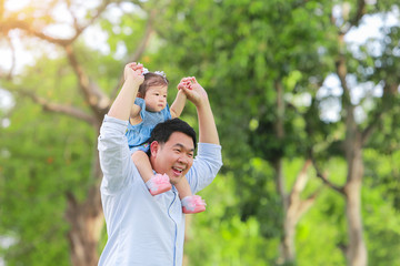 Fototapeta premium Father and son walking on the field at the garden. Concept of family.