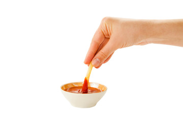 Hand holds fries in socket cup with ketchup isolated on white background.