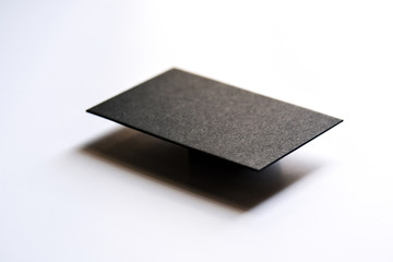 Mockup of blank textured black business card at white background