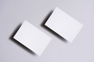 Photo of blank white business cards on white. Mock-up for branding identity. For graphic designers presentations and portfolios