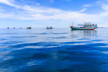 Fishing boat floating in the sea. The beautiful bright blue sky.