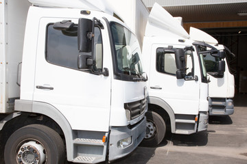 closeup of three trucks lined up park white truck