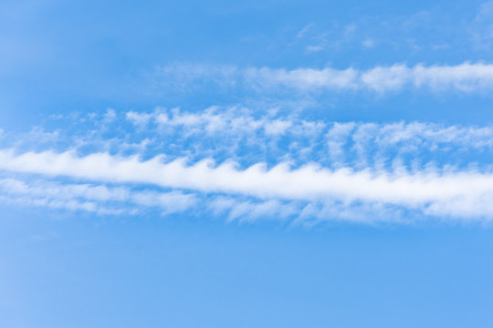 Kelvin Helmholtz instability clouds wavy on blue sky.