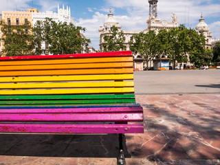 bench in a park painted in the colors of the rainbow flag in Valencia, Spain
