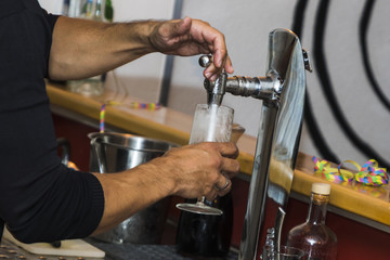 Fototapeta na wymiar Bartender pouring fresh cold beer from tap