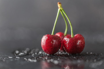 Fresh cherry with water drops on dark stone background. Fresh cherries background. Healthy food concept