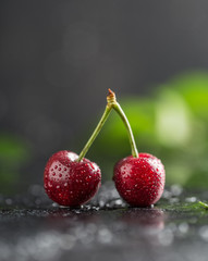 Fresh cherry with water drops on dark stone background. Fresh cherries background. Healthy food concept