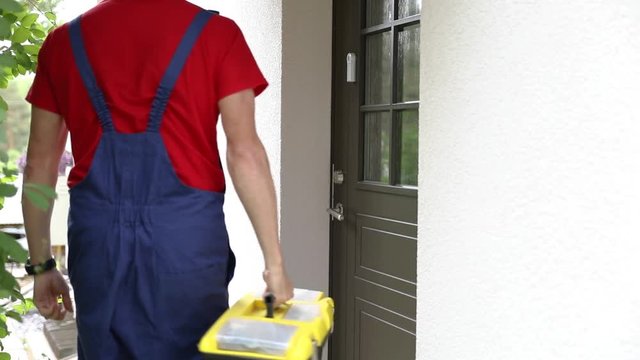 worker with tool box walk to a client house and ring the doorbell