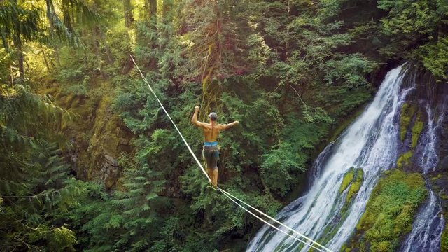Fit Man Highlining Over A Waterfall In Oregon