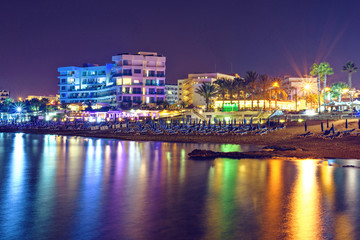 Fototapeta na wymiar Night cityscape with beachline, lights glowing on buildings