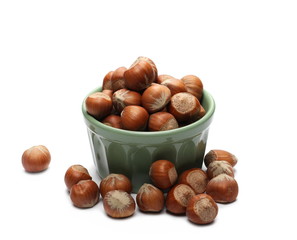 Hazelnuts in green porcelain bowl isolated on white background