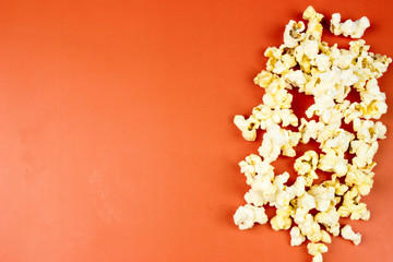 Popcorn on orange texture. Food concept. Empty space for text