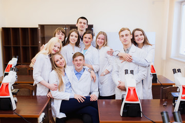 Obraz na płótnie Canvas Medical education. A large group of doctors students in the office with microscopes, the team passed the exam on microbiology