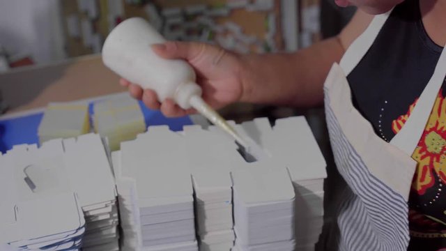 woman wear glue on packing products and glue a transparent film.