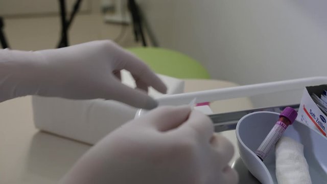 Nurse puts on bar code sticker on vacutainer after blood draw for identification