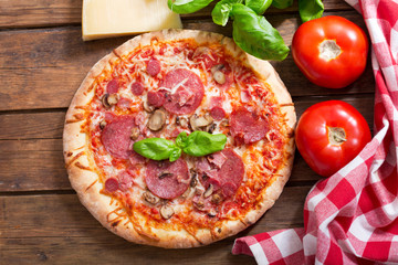 pizza with ham, salami and mushrooms, top view