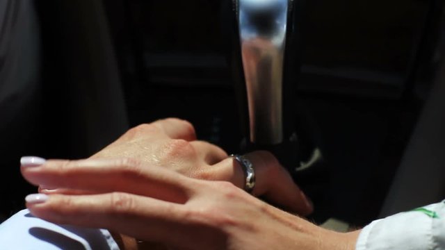 woman caresses partner hand in driving car closeup