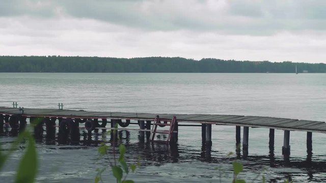 View of woman walking on old wooden pier