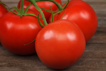 Branch fresh red tomato on wooden background