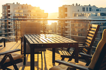 Outdoor Terrace With Garden Furniture In The Background Of The City And Sunset. Luxuary Apatraments Resort Recreation Summer Concept