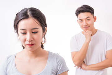 Couple in trouble. Young man looking at her girlfriend with a sly smile.