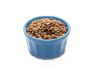 Pile of green lentils in blue porcelain bowl isolated on white background