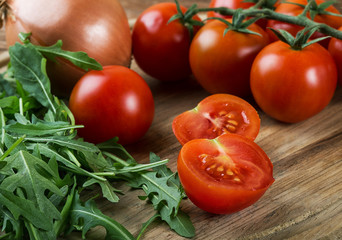 still-life from a tomato arugula and onions on a rustic table large