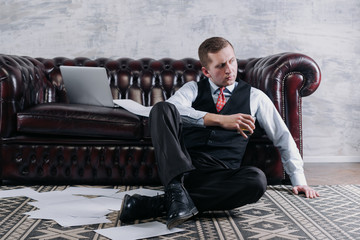 young businessman tired after a workday's.Handsome serious man taking a sip of whisky