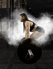Fototapeta na wymiar Woman workout with barbell at gym