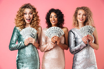 Three beautiful excited women in shiny dresses