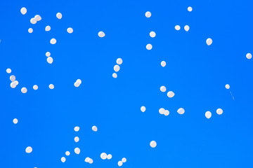 White balls flying in the blue sky