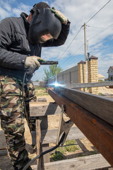 Fototapeta premium Welder welds metal at the construction site