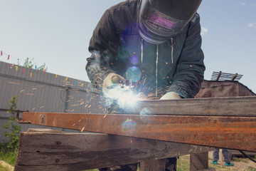 Welder welds metal at the construction site