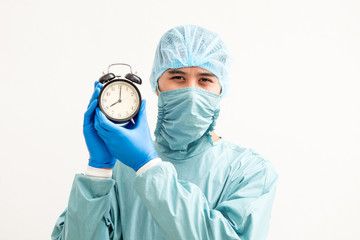 Portrait of a young surgeon with clock alarm over white background.
