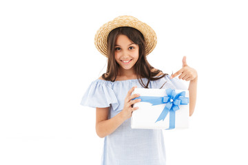 Smiling young brunette girl in dress and straw hat