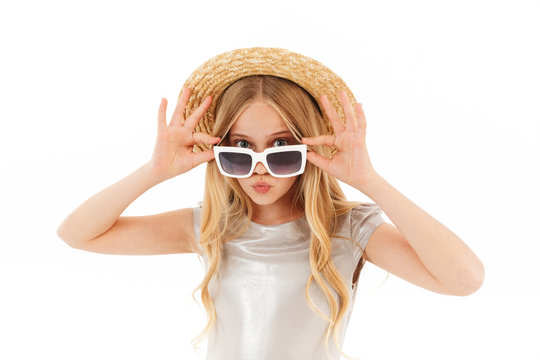 Carefree young blonde girl in dress, straw hat and sunglasses
