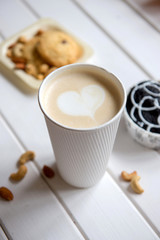 Cup of coffee on wood background with snacks