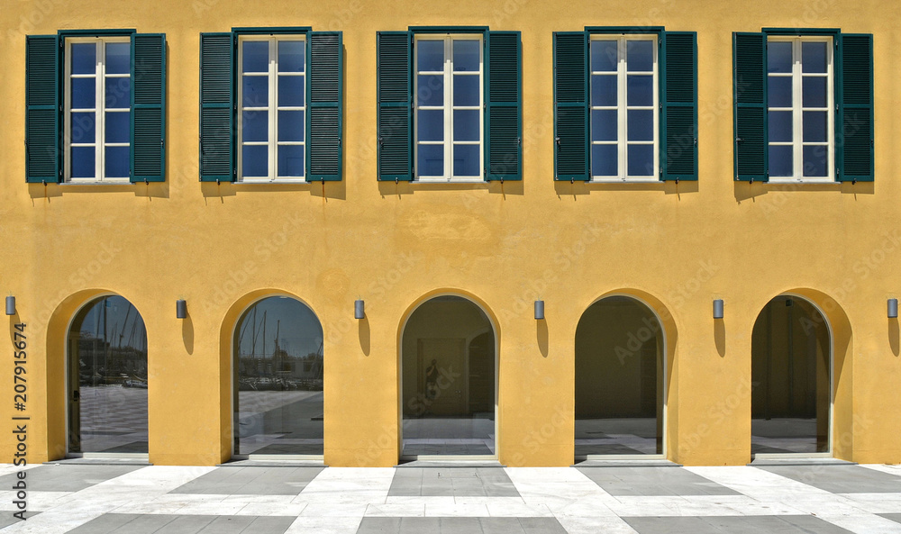 Wall mural beautiful yellow art facade of old architecture building and windows and columns in livorno tuscany,