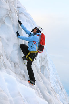 Young woman climbing on the glacier. Falljokull Glacier (Falling Glacier) in Iceland