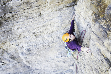 Man rock climber. Rock climber climbs on a rocky wall. Man makes hard move.