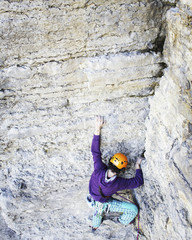 Man rock climber. Rock climber climbs on a rocky wall. Man makes hard move.