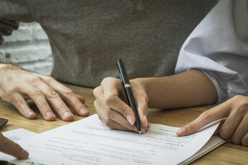 Contract signature for business and financial contract.  Sign on the dotted line.  Male caucasian pen signs a paper.