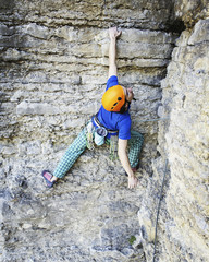 Man rock climber. Rock climber climbs on a rocky wall. Man makes hard move.