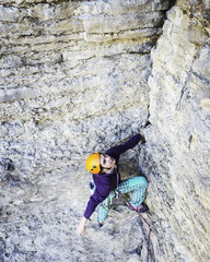 Man rock climber. Rock climber climbs on a rocky wall. Man makes hard move.