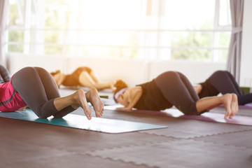 Obraz na płótnie Canvas Women exercising in fitness studio yoga classes