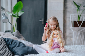 little daughter playing mother with doll