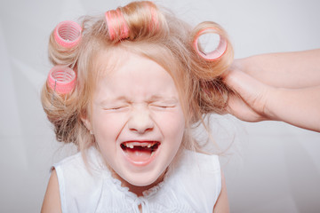 cute little girl on morning. studio shot.Happy funny child little girl with hair curlers.Portrait...