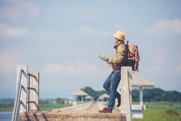 backpackers or Hikers are reading maps on the river bridge as a tourist attraction.