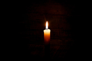 Fototapeta na wymiar candle on old wooden background